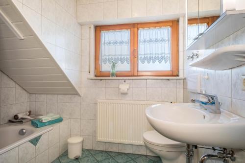 a white bathroom with a sink and a toilet at Ferienwohnung Monninger in Langenargen