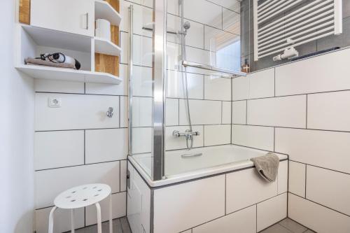 a white bathroom with a sink and a stool at Storchenblick in Wunstorf