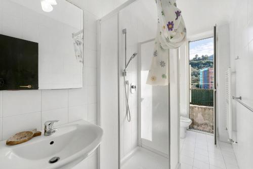 a white bathroom with a sink and a shower at Casa Terrazza Marino in Levanto