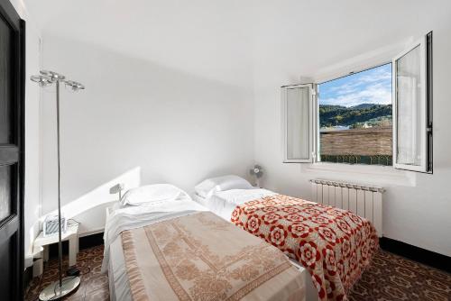 two beds in a white room with a window at Casa Terrazza Marino in Levanto