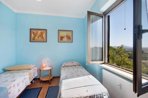 a room with two beds and a large window at Casa Vera in Gavi