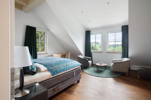 a bedroom with a bed and two chairs at Chalet Foret - Ferienhaus in Todtnauberg