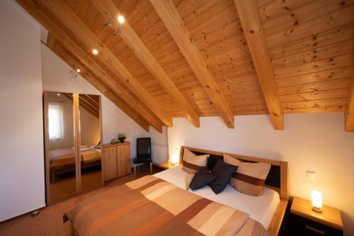 a bedroom with a large bed and wooden ceilings at Ferienhaus Hulda in Öhningen
