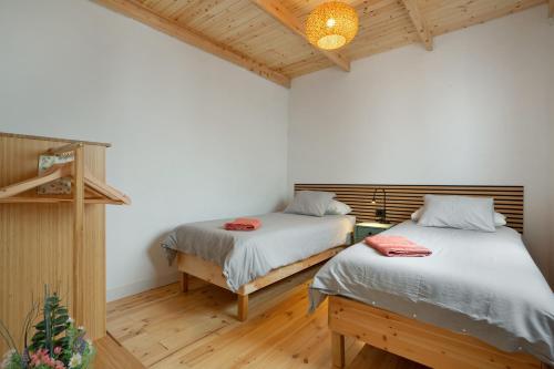 two beds in a room with wooden floors at Picarus Home in Tacoronte