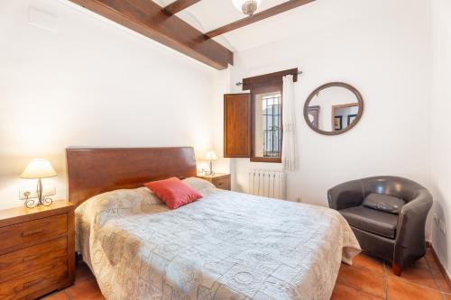 a bedroom with a bed and a chair and a mirror at Cueva Del Sereno in Chulilla