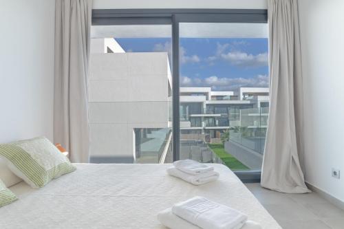 a bedroom with a bed and a large window at Palacio de pilas 22 in Zahara de los Atunes