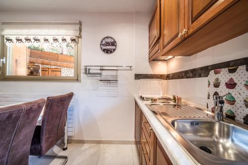 a kitchen with wooden cabinets and a sink at Au Rêve Savoyard 1 - 2 personnes in Morillon