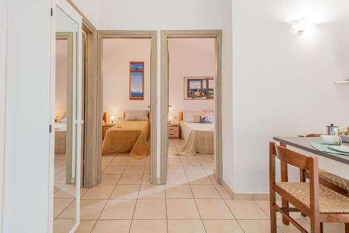 a room with a kitchen and a room with a bedroom at Appartamenti Le Querce App. Mirto in Capoliveri