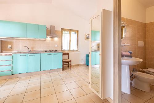 a bathroom with blue cabinets and a sink and a toilet at Appartamenti Le Querce App. Mirto in Capoliveri