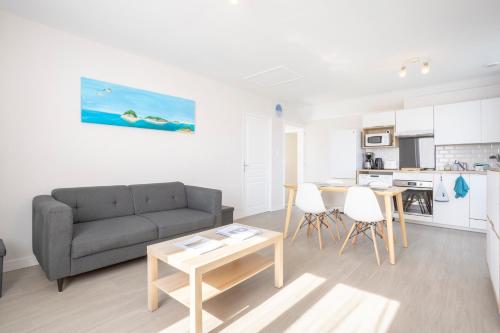 un soggiorno con un divano e un tavolo di Appartement Drenec a Fouesnant