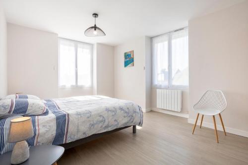 una camera da letto con un letto e una sedia di Appartement Drenec a Fouesnant