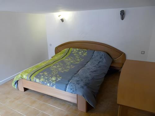a bed with a wooden frame in a room at L'alouette - Gites Rocheflamme in La Malène