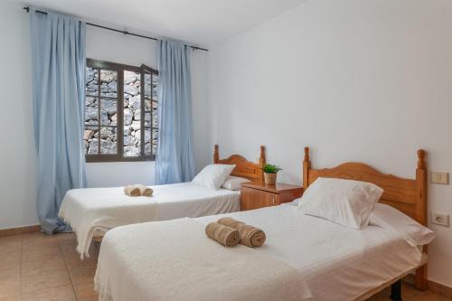two beds in a room with blue curtains at Villa Timanfaya in Tías