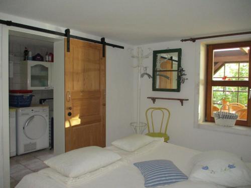 a room with a bed and a kitchen with a window at Altes Jägerhaus in Lübbenow