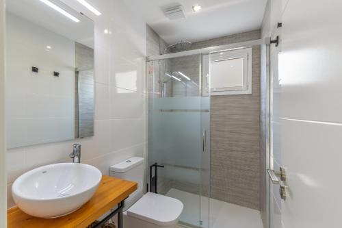 a white bathroom with a sink and a shower at El racó del Mas in Canet de Mar