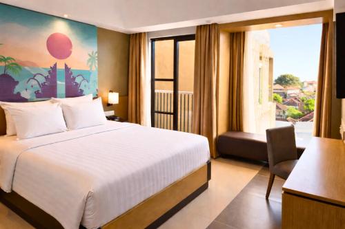 a hotel room with a bed and a window at Metland Seva Seminyak - Formerly Horison Ultima Seminyak in Seminyak