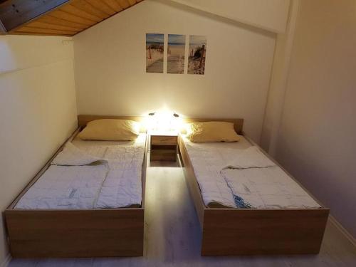 two beds in a small bedroom with a light on it at Ferienwohnung Meerblick in Wangerland