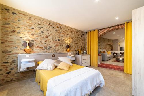 a bedroom with two beds and a living room at Plaisir des pierres in Rivesaltes