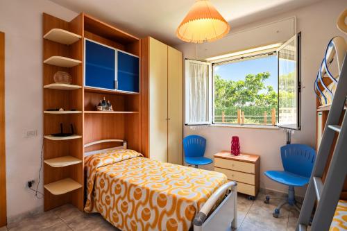 a bedroom with a bed and a desk and a window at Villa Minetta in Leporano Marina