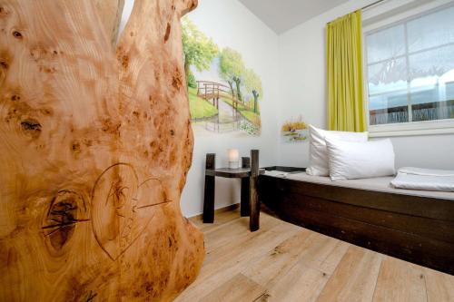 a room with a bed with a large wooden headboard at Ferienwohnung Fliess in Neuendorf am See