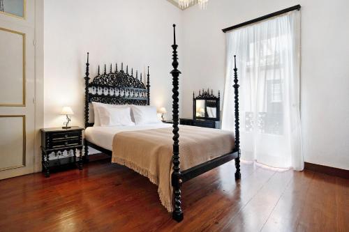 a bedroom with a large bed with a wooden floor at Sé Heritage in Angra do Heroísmo