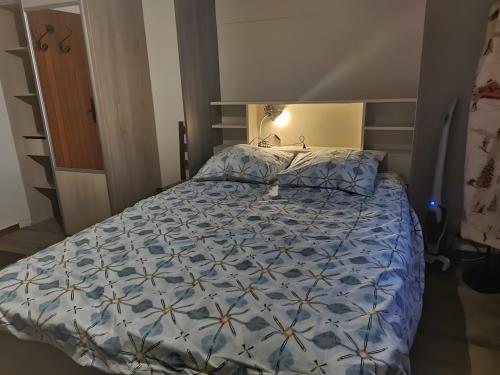 a bedroom with a bed with a blue comforter at Studio Fontanarosa centre station in Vars