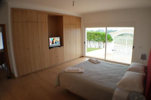 a bedroom with a large bed with a large window at Casa do Mar in Albufeira