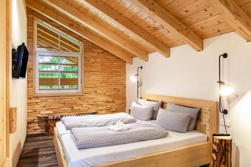 two beds in a room with a wooden wall at Chalet Rauschn 2 in Farchant