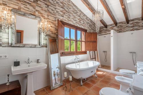 a bathroom with a tub and a sink and a toilet at Son French in Algaida