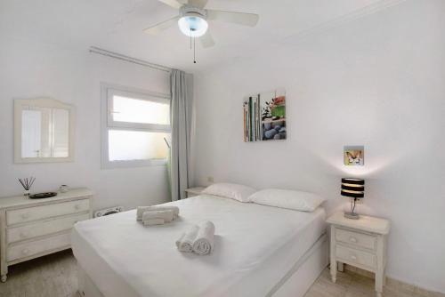 a white bedroom with a white bed and a window at Ceyla in Arona