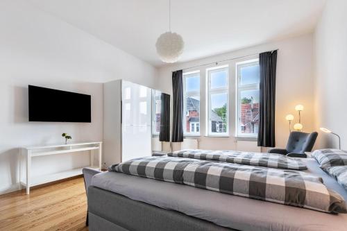 a bedroom with two beds and a flat screen tv at Villa Elysium in Heide