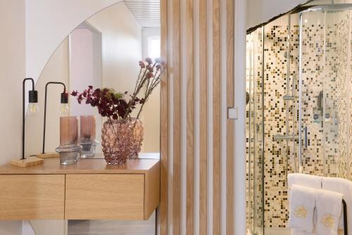 a bathroom with a vase of flowers on a table at Prestigegoldresidence 2 - Old Town in Guimarães