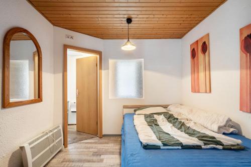 a bedroom with a bed and a wooden ceiling at Bungalow 145 in Zeulenroda