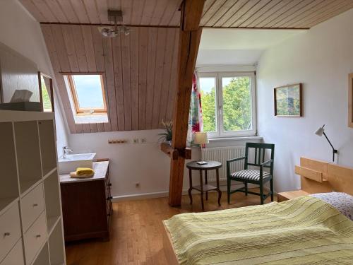 a bedroom with a bed and a table and a chair at Ferienwohung Rotkehlchen in Kurort Gohrisch