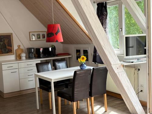 a dining room with a white table and black chairs at Ferienwohung Rotkehlchen in Kurort Gohrisch