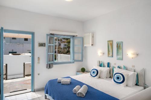 a bedroom with a bed with blue and white pillows at Pico Bello Patmos 10 in Patmos