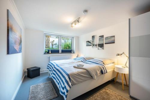 a white bedroom with a bed and a sink at Meerlust Travemünde in Travemünde
