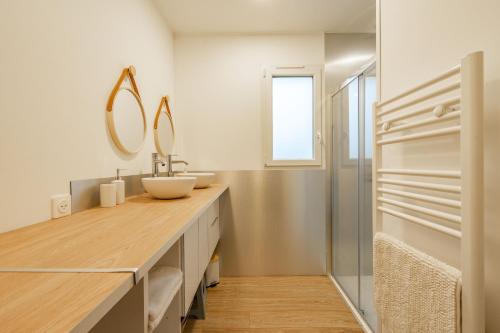 a bathroom with a sink and a mirror at L'instant fleuri in Saint-Hippolyte