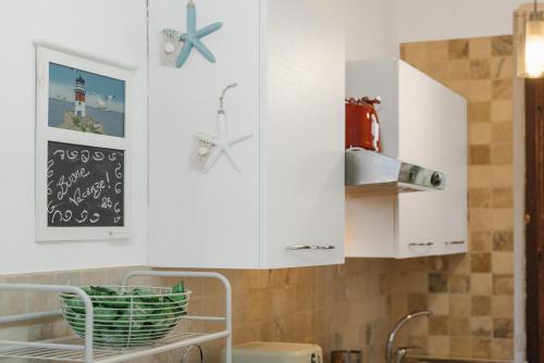 a kitchen with white cabinets and a sink at Kai Mālie Villasimius in Villasimius