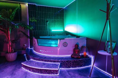 a hot tub in a room with green and purple lighting at Melin Spa Suite – Wellness, Garten in Marl