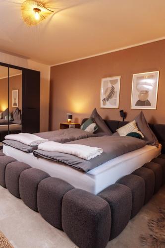 a large bed with a large couch in a room at Melin Spa Suite – Wellness, Garten in Marl