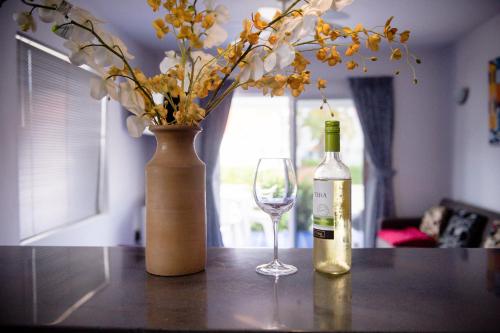 a bottle of wine and a vase with a glass at Marazul Dive Resort in Sabana Westpunt