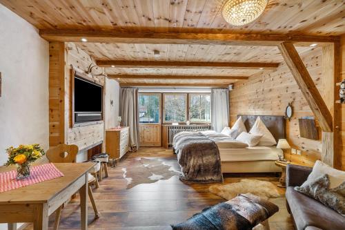 a bedroom with a large bed in a room with wooden walls at Chalet Gipfelblick Inzell in Inzell