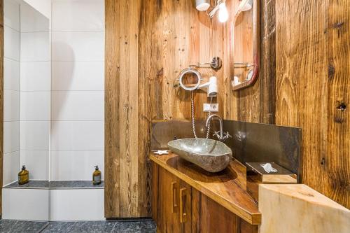 a bathroom with a sink and a wooden wall at Chalet Gipfelblick Inzell in Inzell