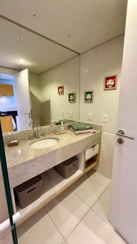a bathroom with a sink and a large mirror at Granja Brasil , Studio Itaipava in Araras Petropolis