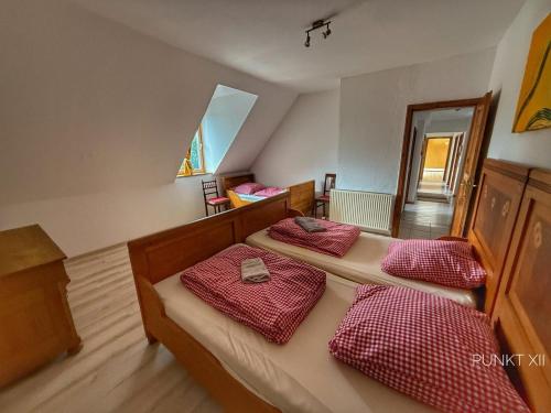 a bedroom with two beds with red and white sheets at Wohnung 1 in Burghaslach