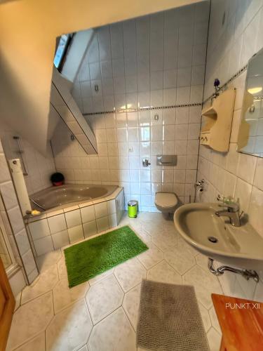 a bathroom with a sink and a toilet and a tub at Wohnung 1 in Burghaslach