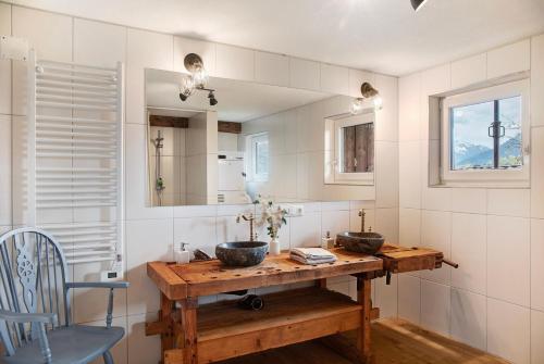 a bathroom with two sinks on a wooden table at Berghof Moosen in Hart im Zillertal