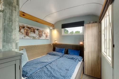 a bedroom with a bed with a blue comforter at Tiny House in Lohfelden