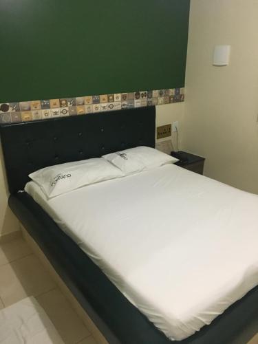 a bed with two pillows on it in a room at Hotel Positano in Taguatinga